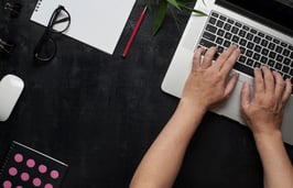 graphicstock-workspace-with-laptop-male-hands-notebookeyeglasses-sketchbook-black-wooden-desk-with-bamboo-leaf-flat-lay-top-view-office-table-desk-freelancer-working-place_ruVMPjwlol